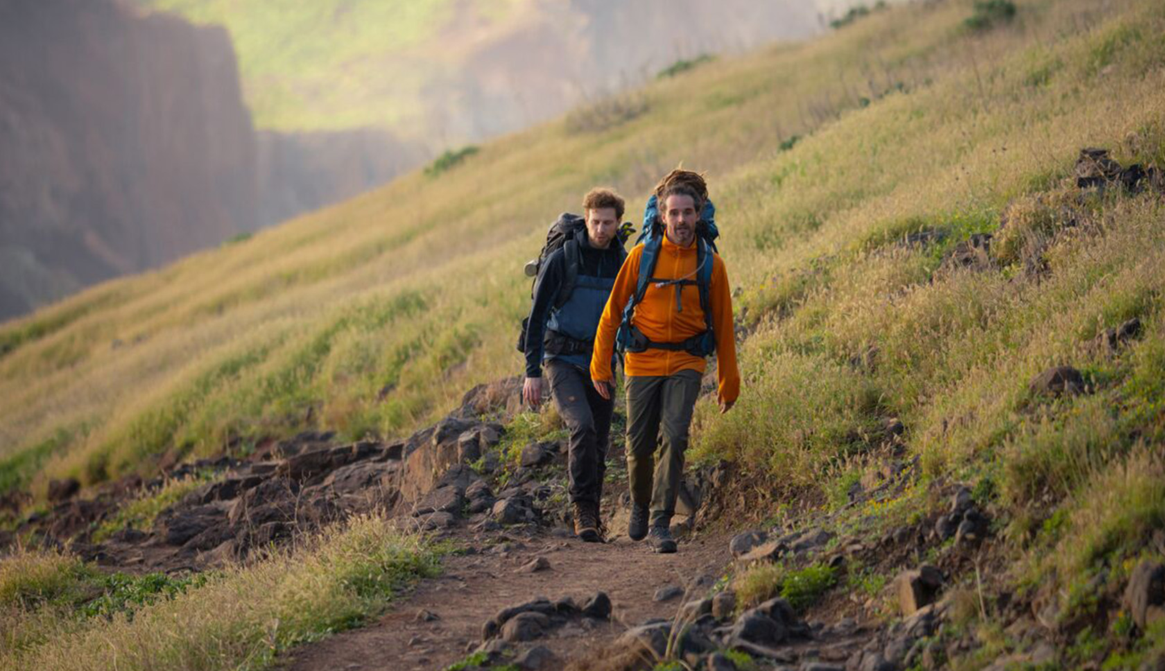 Twee mannen wandelen samen in grassig gebied