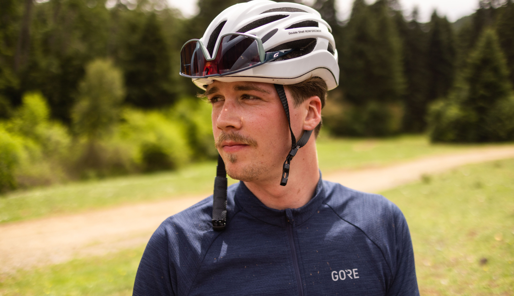 Een fietser met een fietshelm op kijkt opzij.