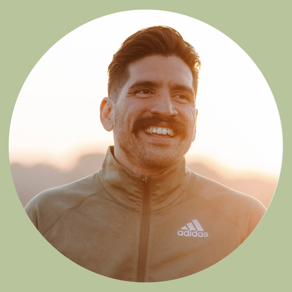 Een man staat in de bergen bij zee