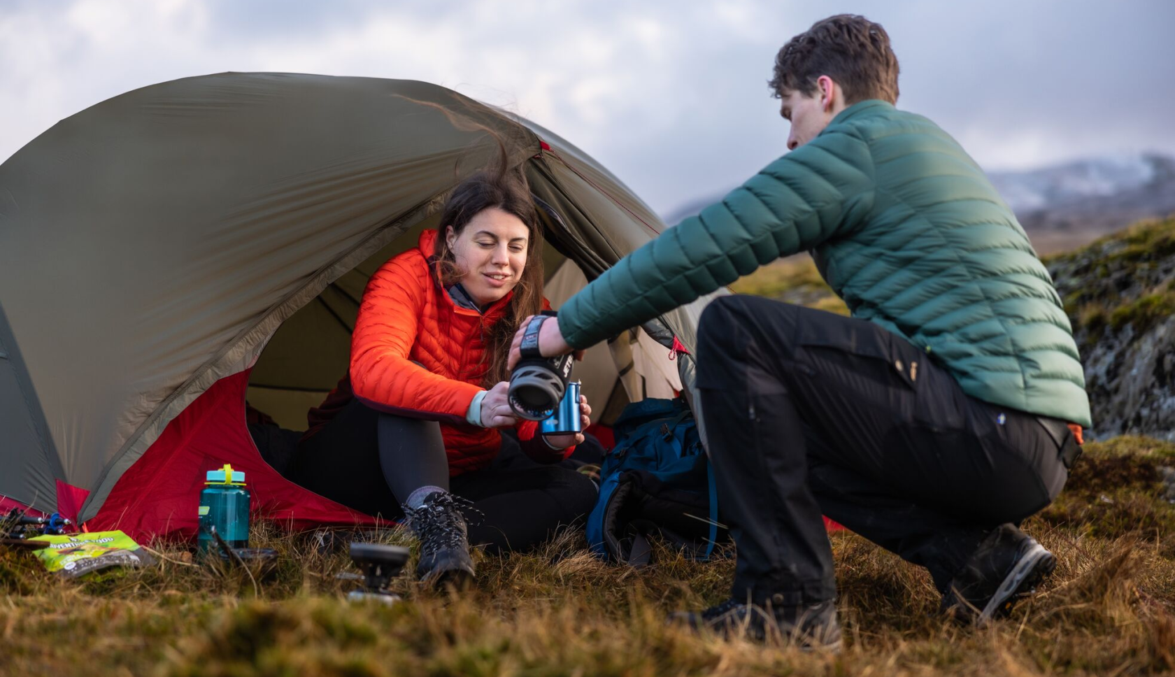 man en vrouw maken warm water bij de tent