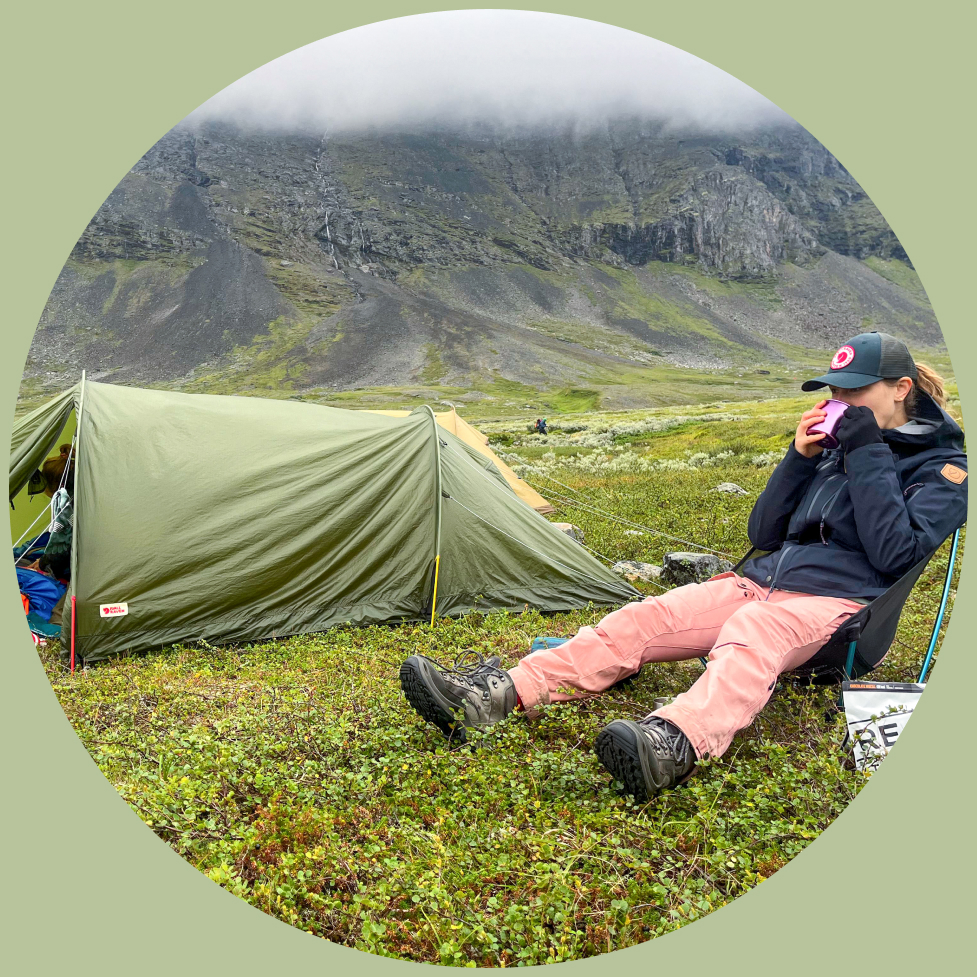 Buitenexpert Lisanne zit voor haar tentje tijdens het wildkamperen in Zweden 