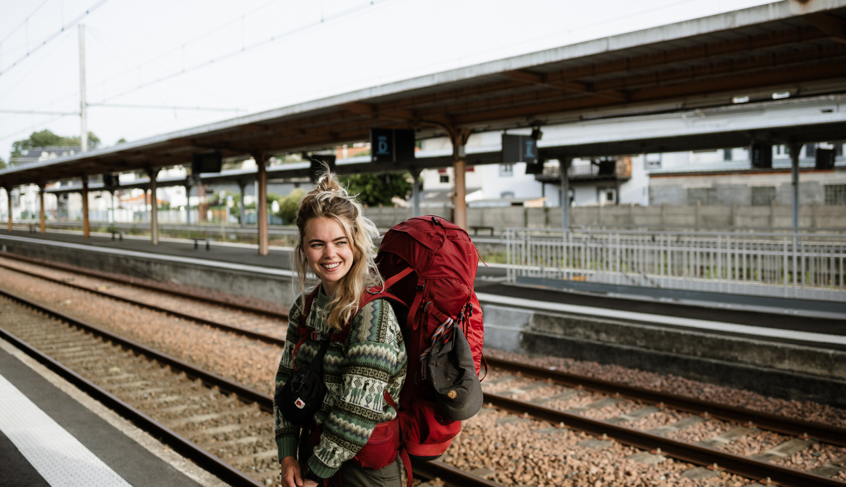 Een backpacker wacht op de trein op het station.