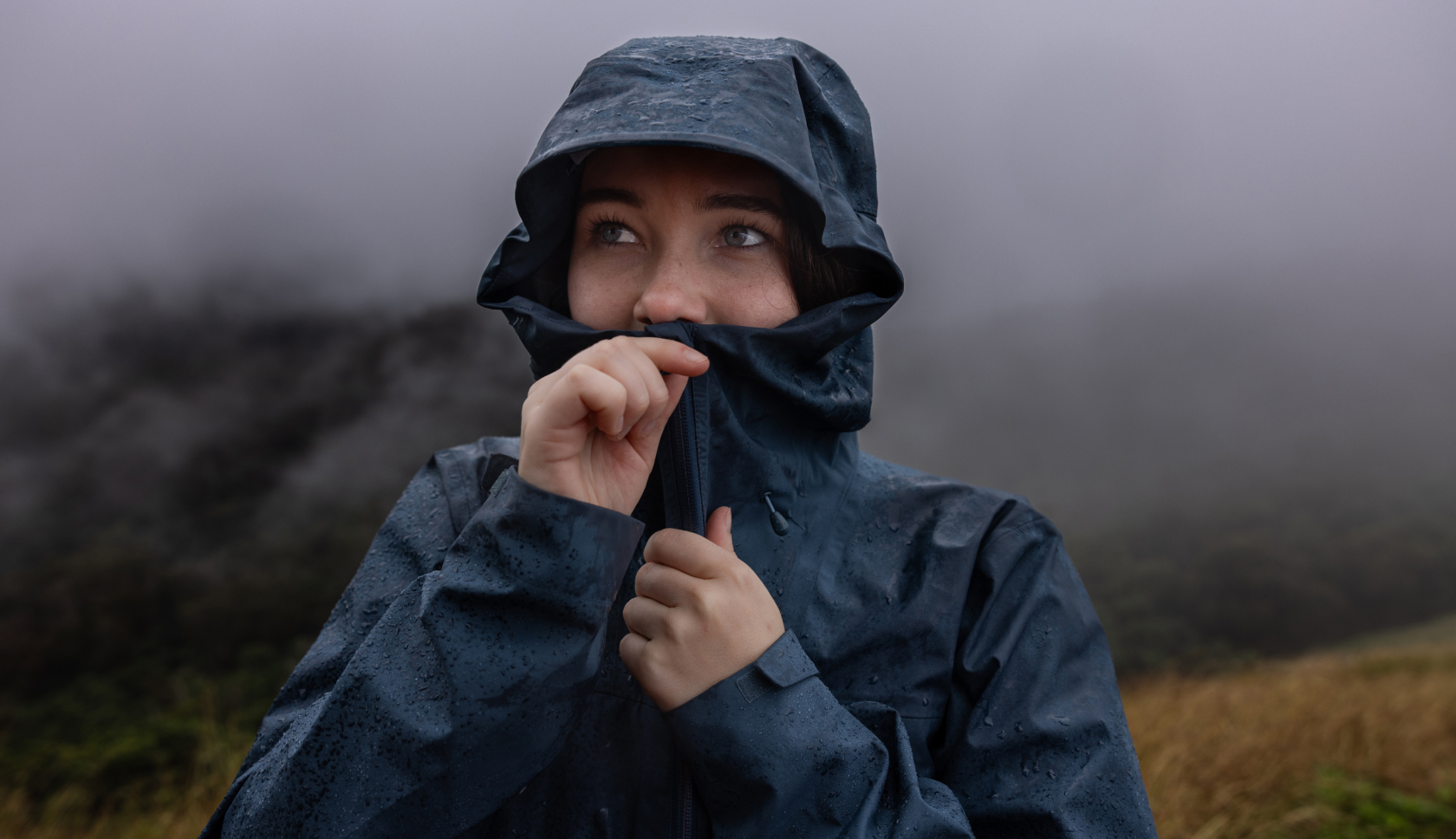 vrouw draagt een donkerblauwe jas in de regen