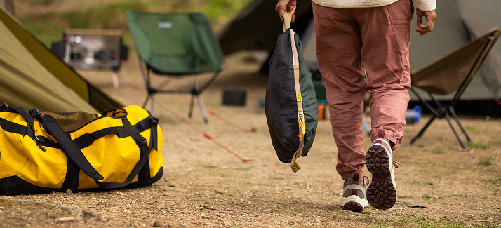 kampeerder loopt met tasje door kamp