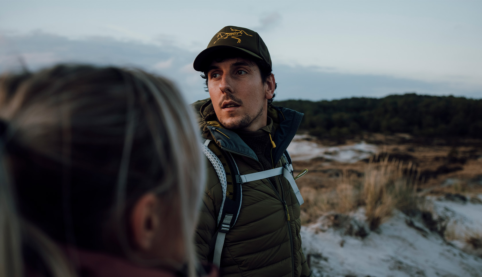 man met een pet op kijkt achterom