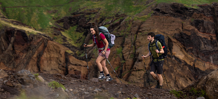 twee mensen wandelen omhoog met wandelstokken en rugzakken