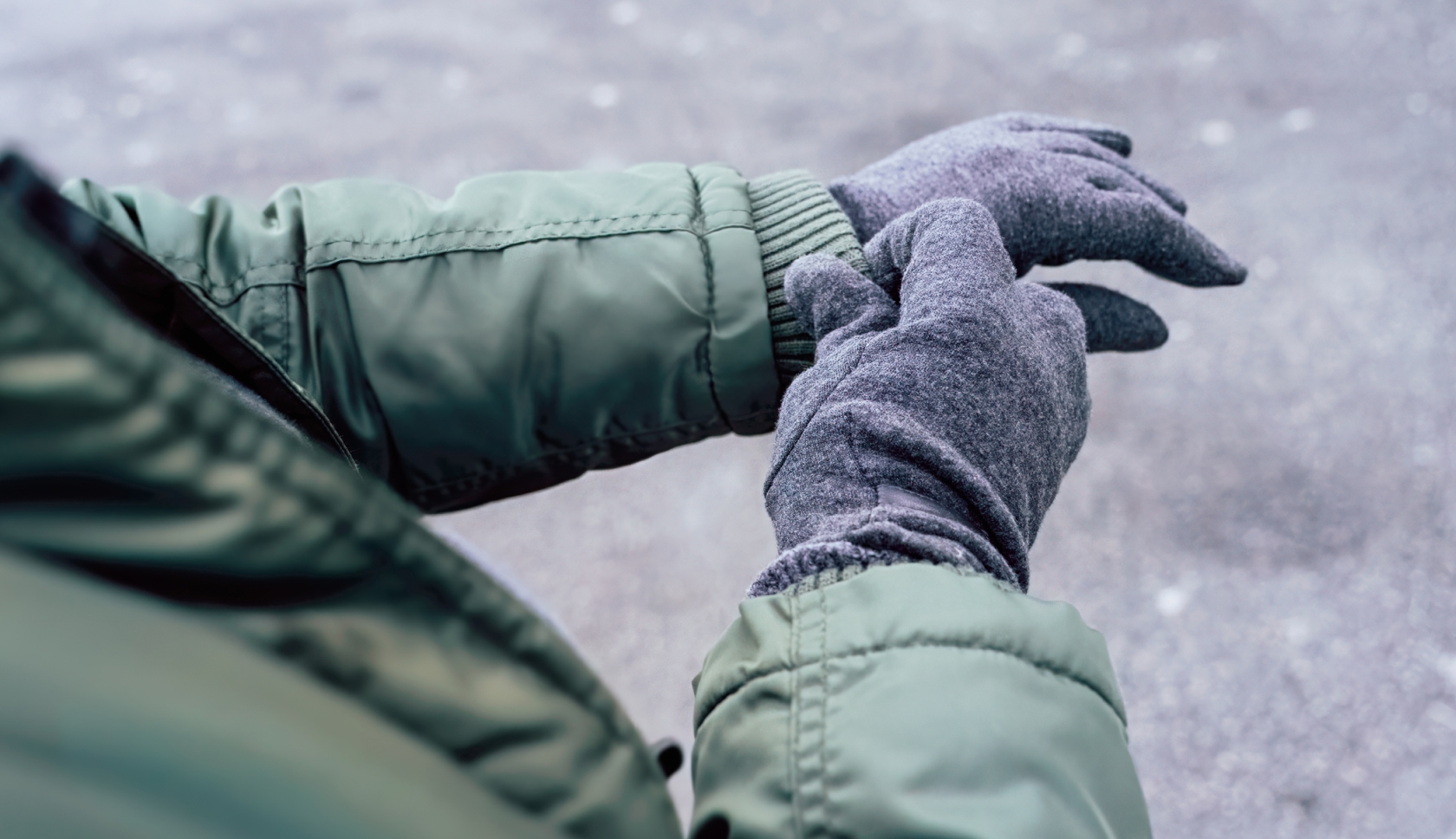 man met gele regenjas en waterdichte handschoenen voelt voor regen in de bergen