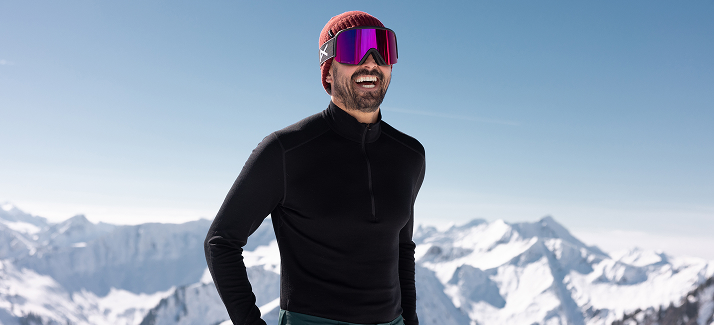 man in thermokleding lacht in de sneeuw