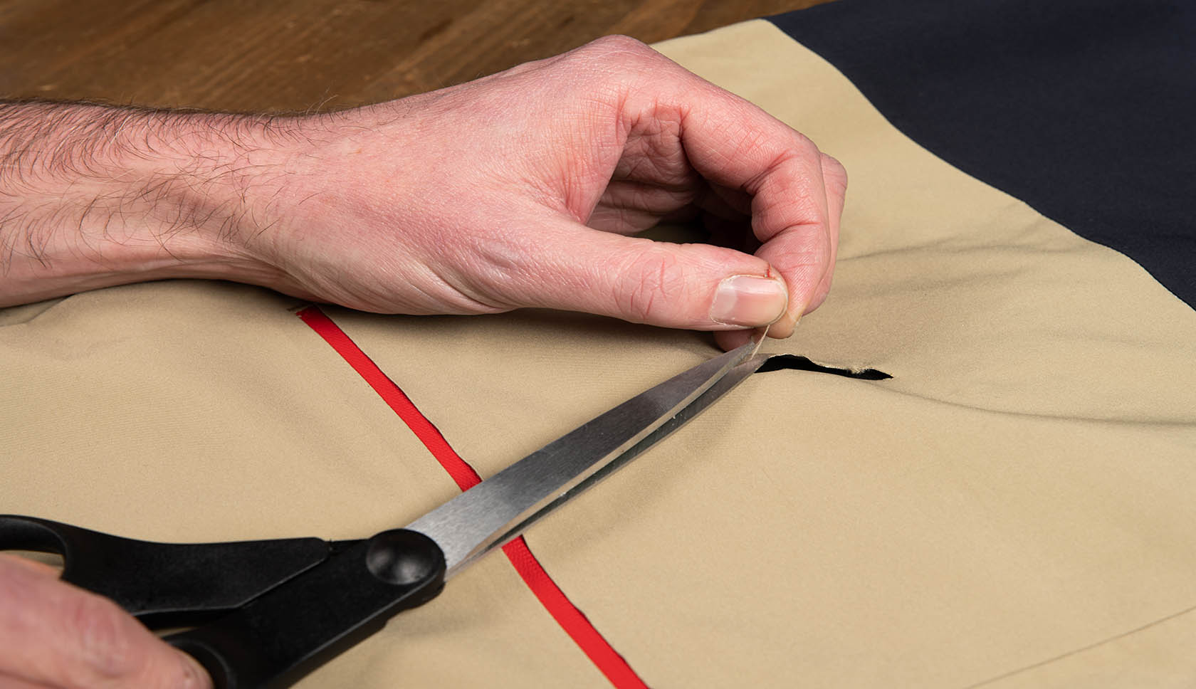 hand knipt draadjes bij het gat weg