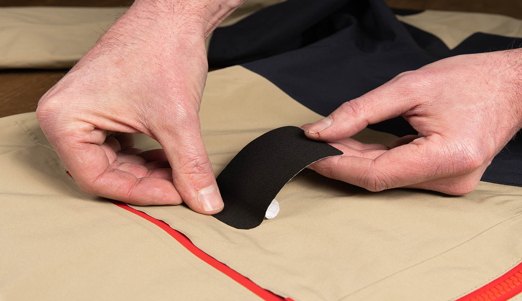 handen plakken de patch voorzichtig over de scheur