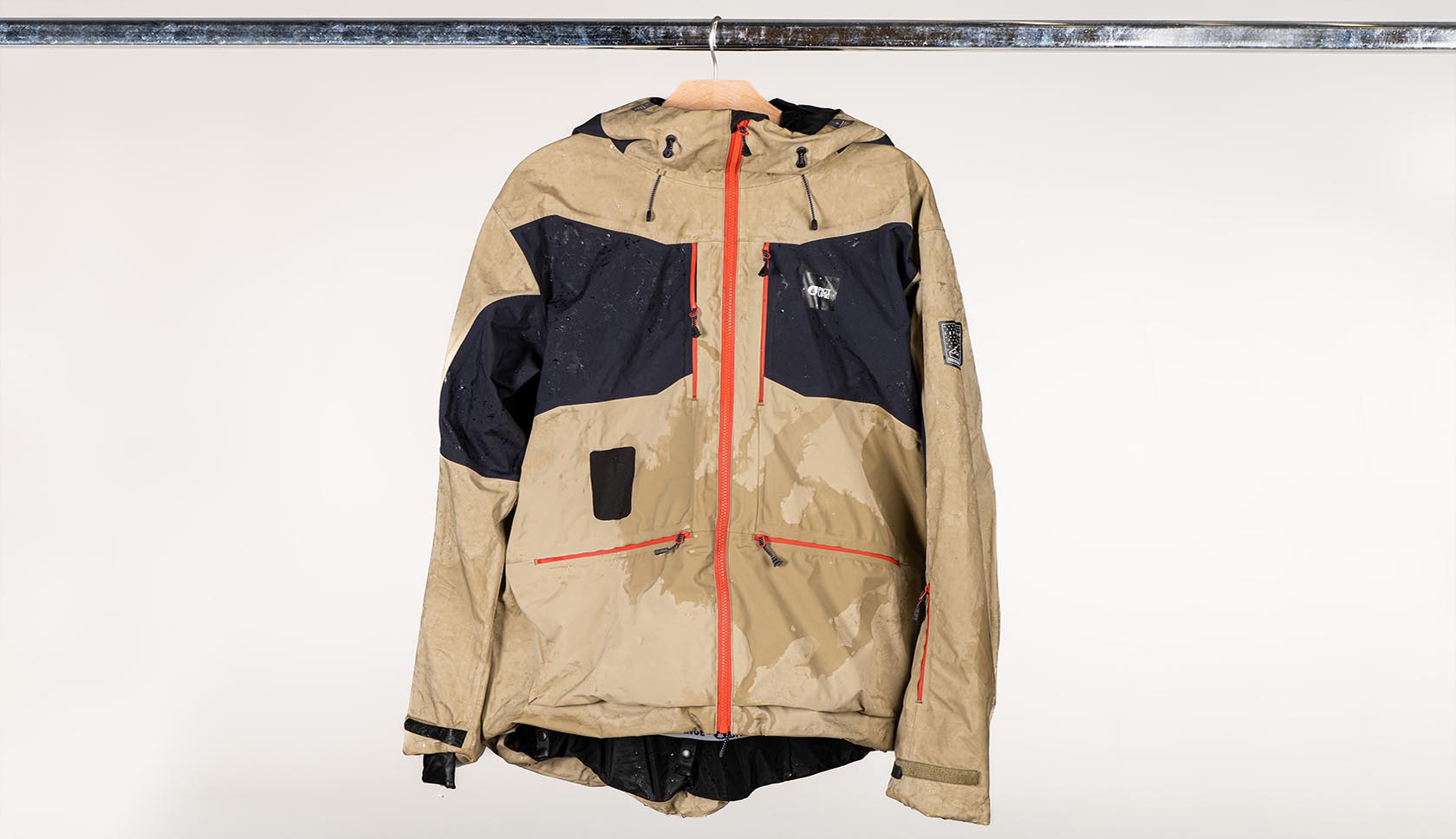 een natta jas hangt te drogen aan een kledingrek