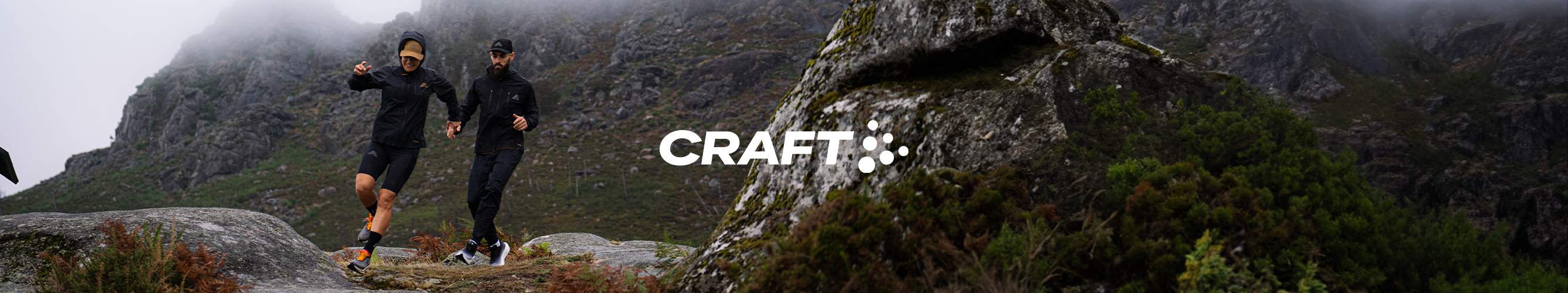 twee hardlopers rennen door mistige bergen