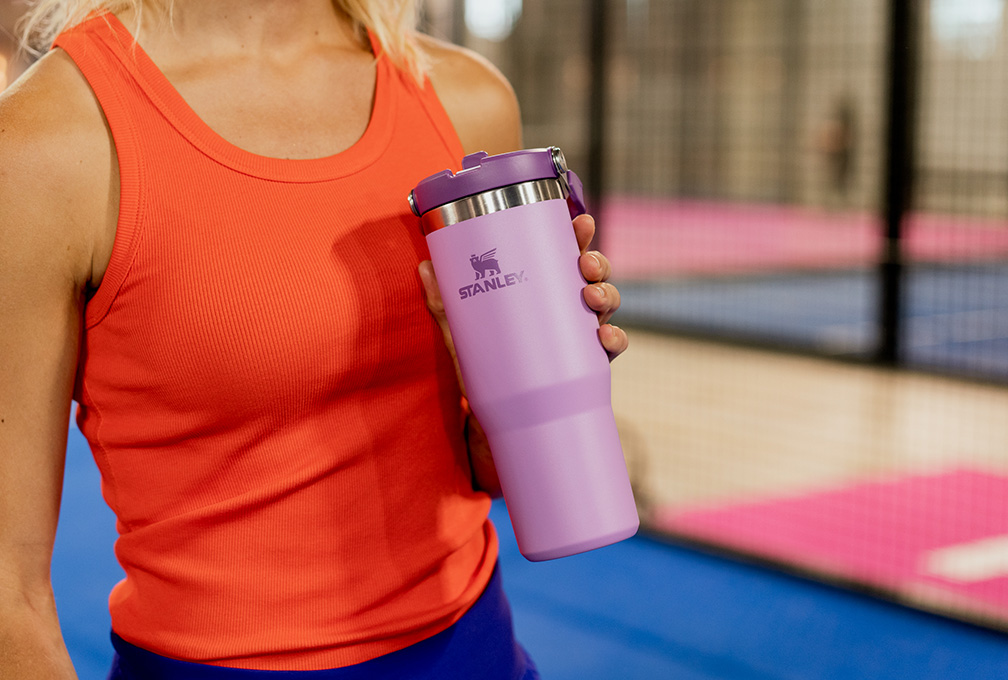 Sportieve vrouw houdt een Stanley-waterfles vast tijdens het sporten