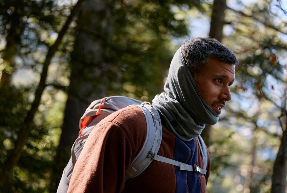 man wandelt door een bos en draagt een buff