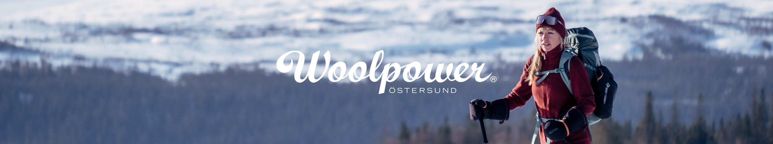 vrouw op ski's loopt door besneeuwd gebied met witte bergen op de achtergrond