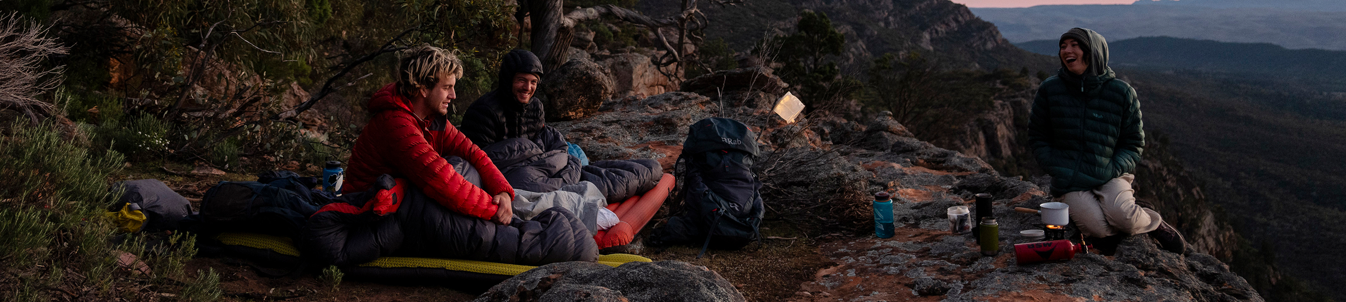 avonturiers in slaapzakken met bergachtig uitzicht